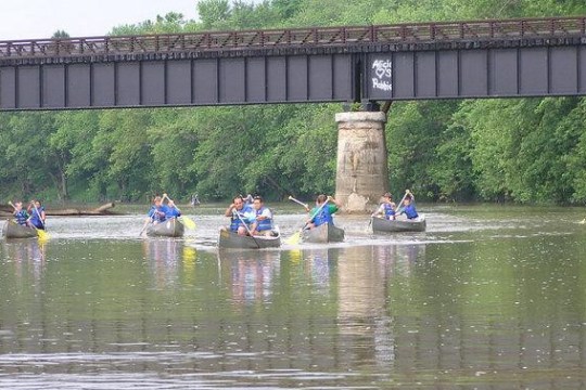 a group of people riding on the back of a boat in the water